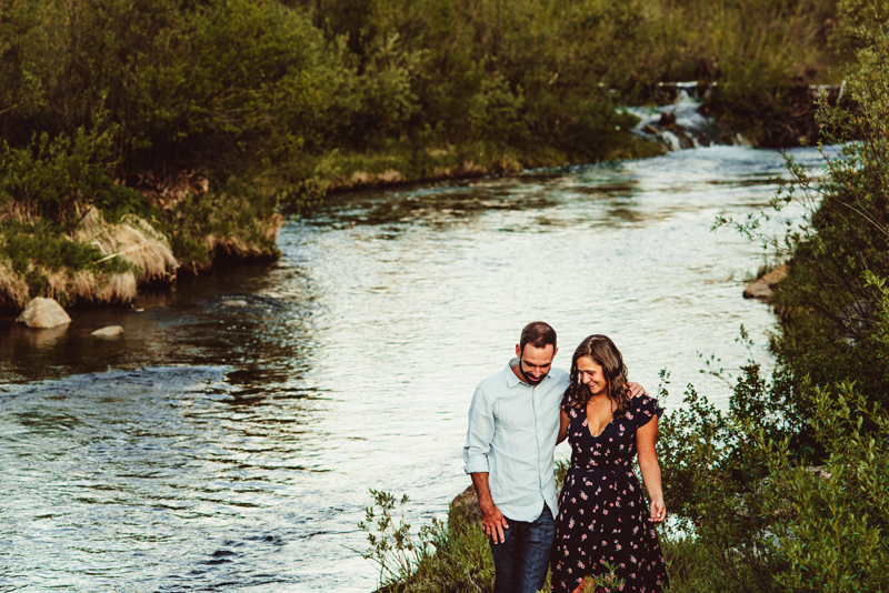 Elopement Photographer, man and woman walk together, arms around each other near a flowing river