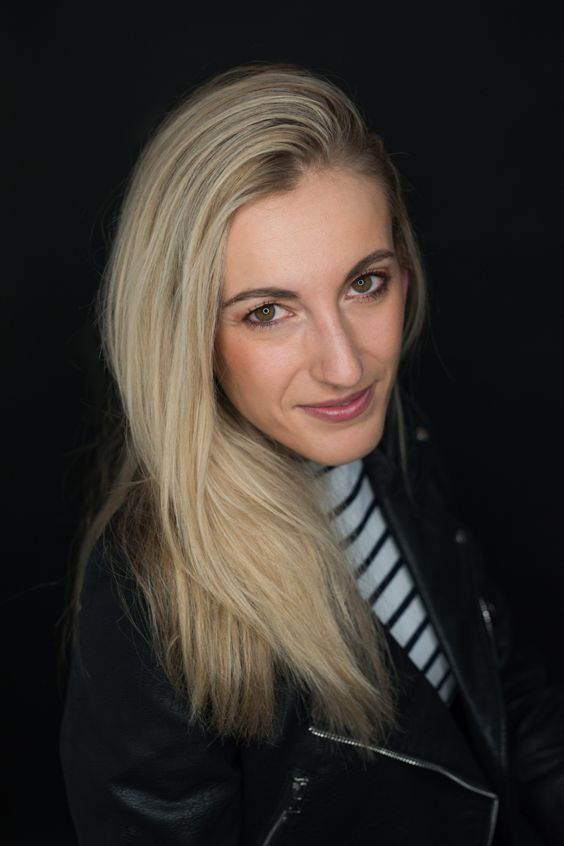Business Photography, blonde caucasian woman wears rose lipstick, a white and navy striped blouse, and a black leather jacket